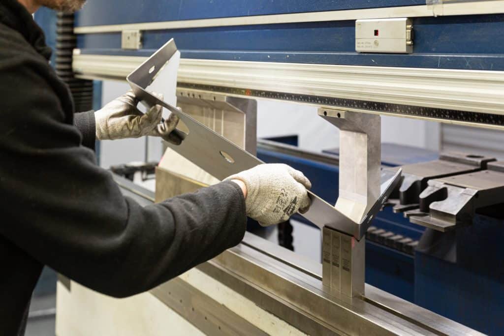 Opérateur en train de plier une tôle en chaudronnerie industrielle