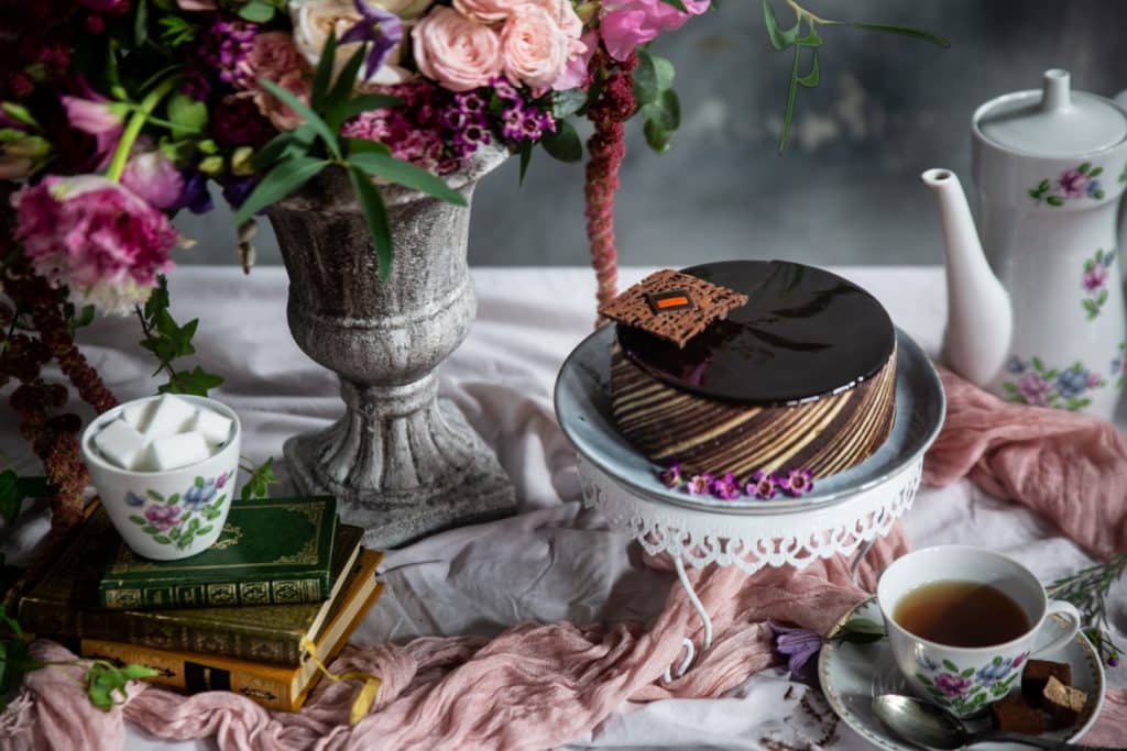 Photo culinaire d'un gâteau au chocolat mise en scène avec une composition florale