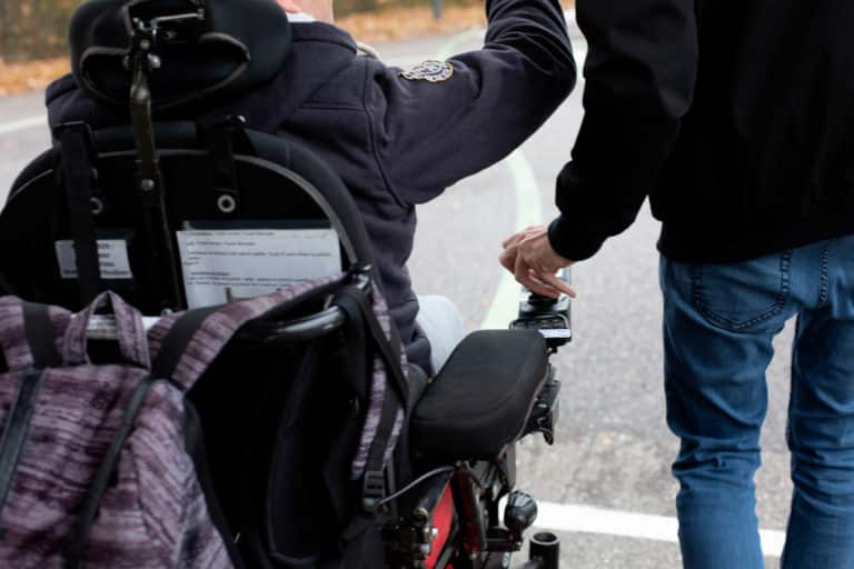 amp qui aide une personne en fauteuil roulant