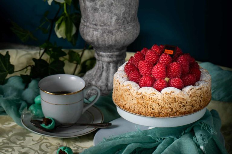 Framboisier posé sur une table à côté d'une tasse de café