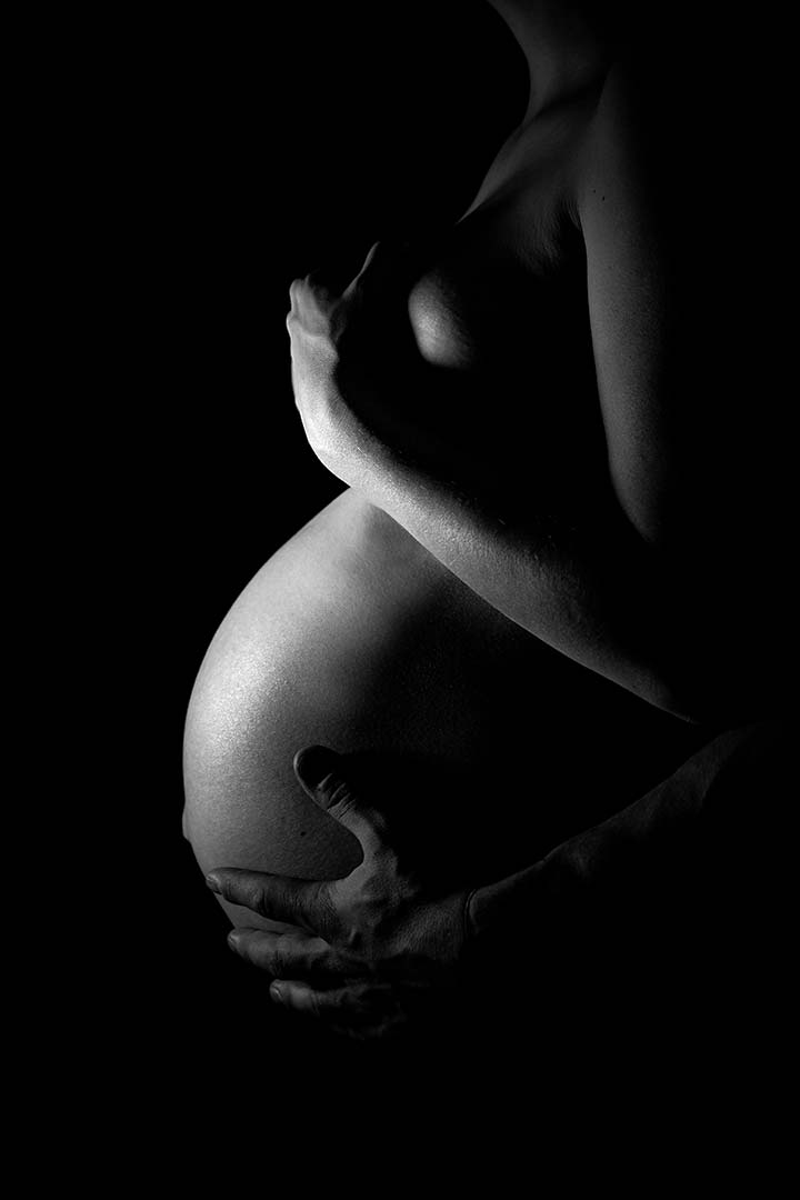 Photo de grossesse en noir et blanc et clair obscur
