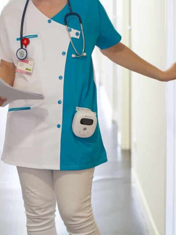 Photo médicale d'une infirmière en blouse en train de sortir d'une chambre