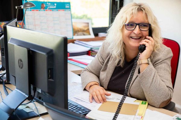 femme assise à son bureau en train de téléphoner