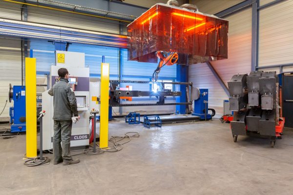 Photo d'un opérateur en train de programmer un robot soudeur en chudronnerie industrielle